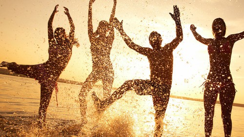 Personas salpicándose agua en la orilla de la playa. Estrés y movimiento